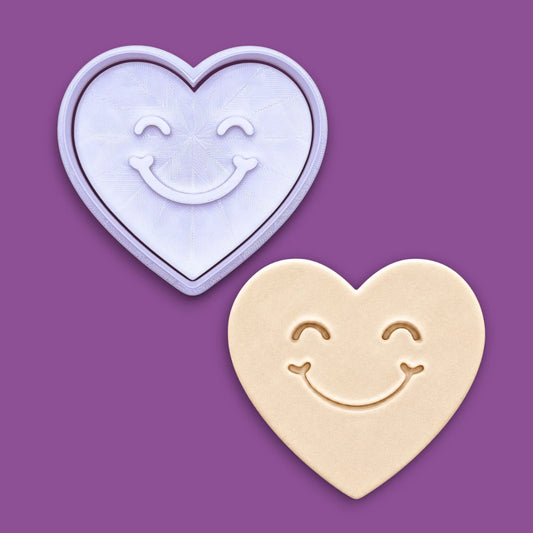 Handmade and customizable heart cookie cutter and stamp with cute face stamp alongside a dough cutout and imprint, perfect for Valentine's Day baking, sweet treats and party favor creations.