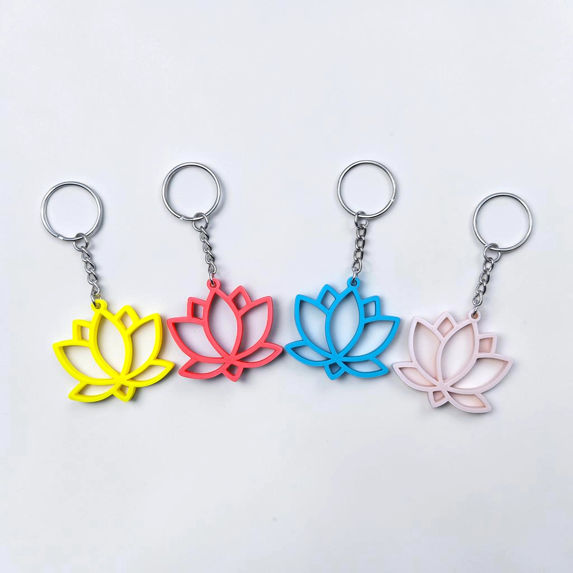 Lotus flower keychains shown in multiple colors, eco-friendly and handmade, perfect for spiritual gifts or mindful accessories.