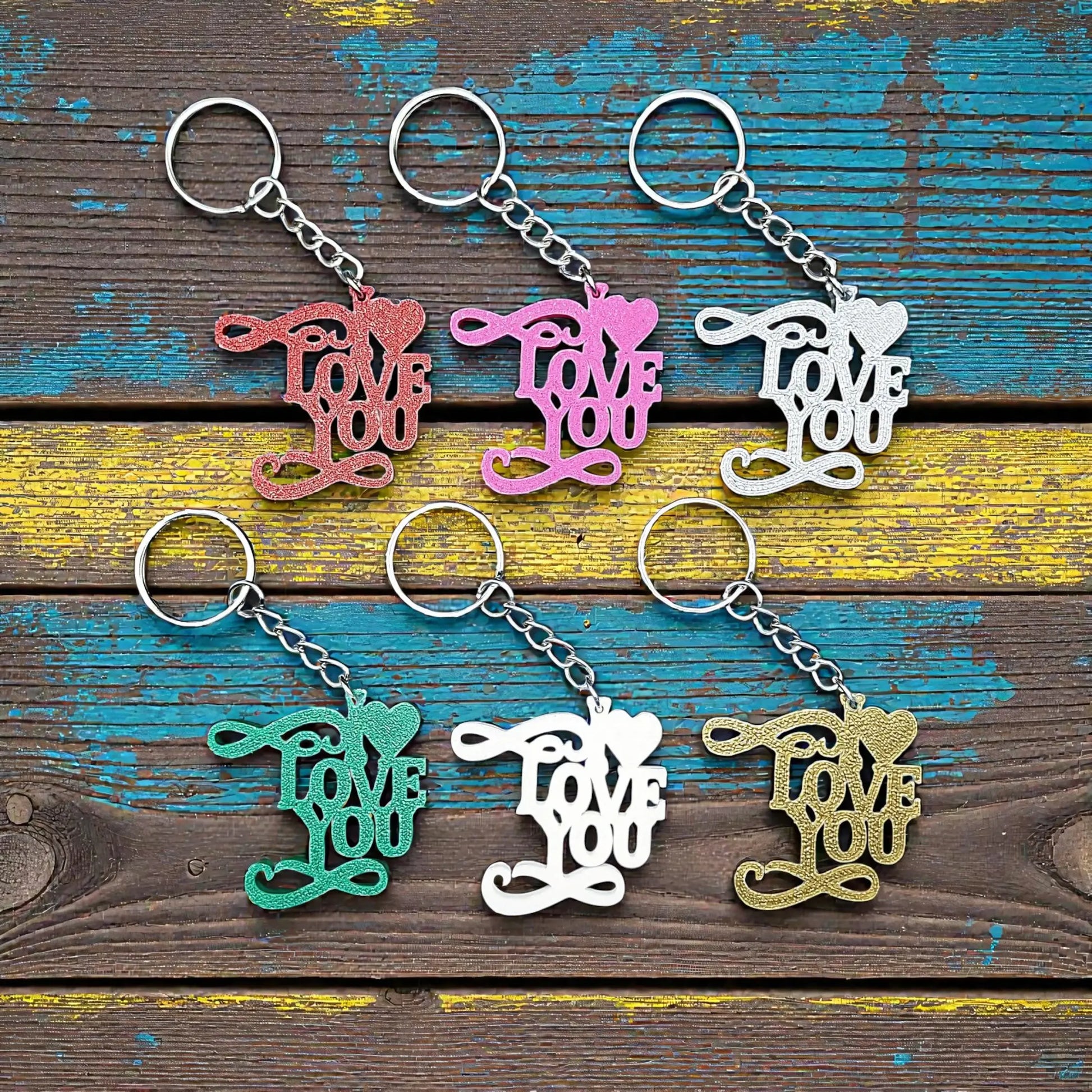 Handmade and customizable I Love You keychains in assorted colors, perfect for classroom prizes, Valentine's Day gifts, party favors for kids birthdays, baby showers and unique backpack charms.