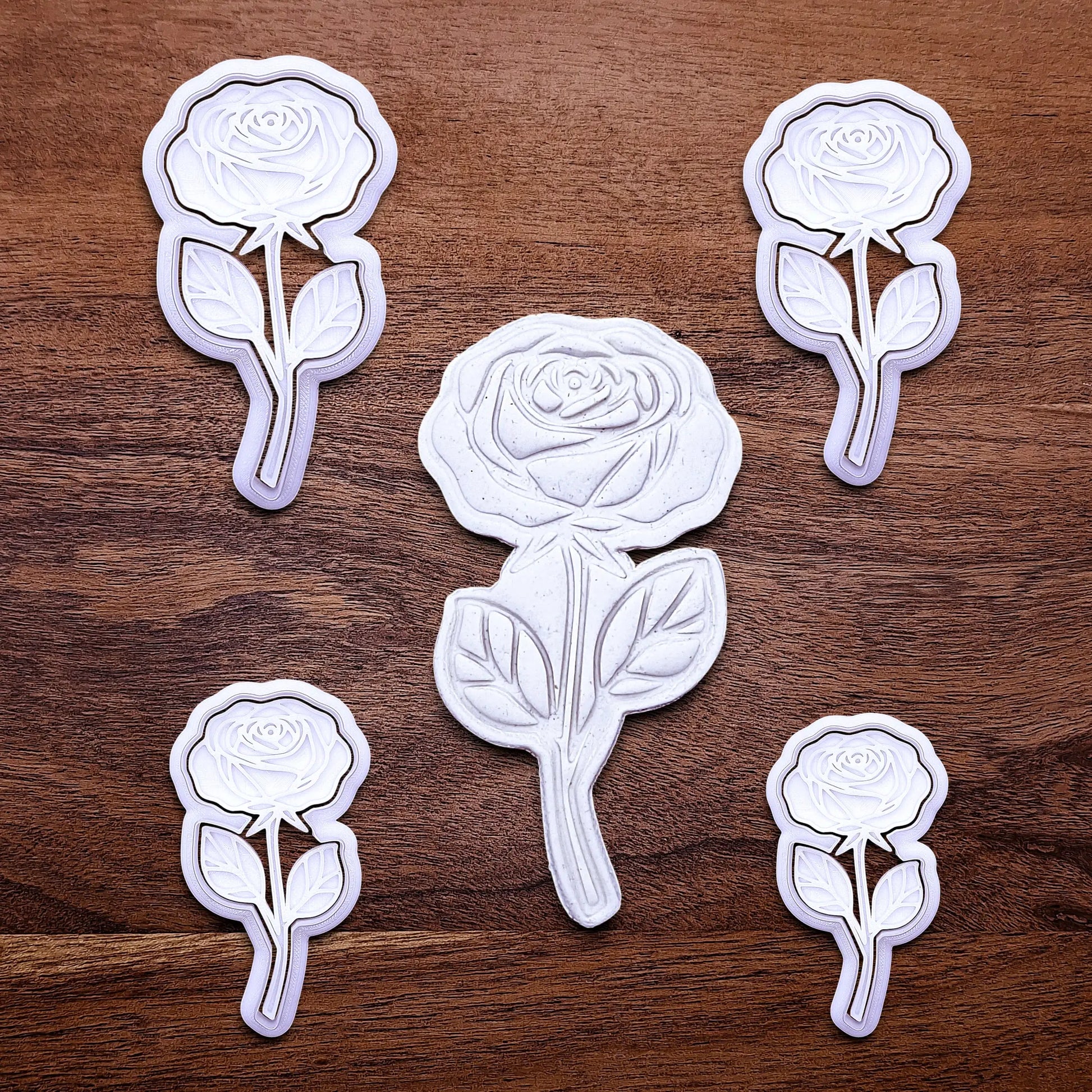 Handmade and customizable Rose Cookie Cutters and Stamps in multiple sizes alongside a dough cutout and imprint, perfect for spring events, romantic weddings, or special occasions.