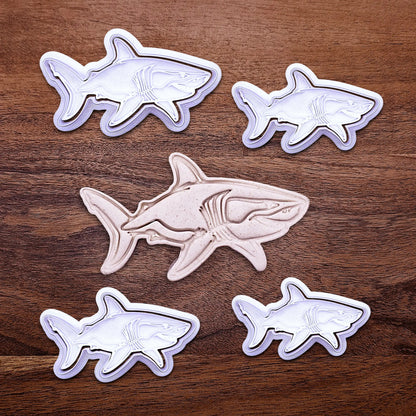 Handmade and customizable shark cookie cutter and stamps alongside a dough cutout and imprint, great for beach themed baking, fondant crafts, or ocean-themed cookies.