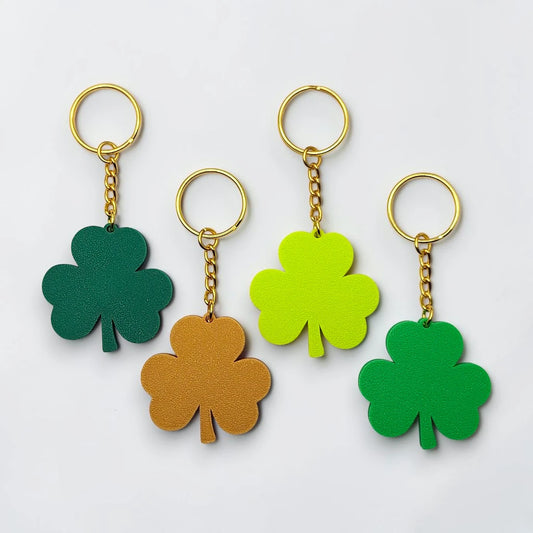 Handmade and customizable shamrock keychains with gold keyrings, perfect for St Patrick's Day party favors and gifts.