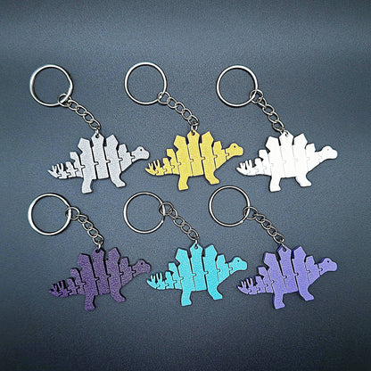 Top view of six fidget dinosaur keychains with articulated segments, ideal for sensory use, kids’ gifts, or dino-themed party favors.