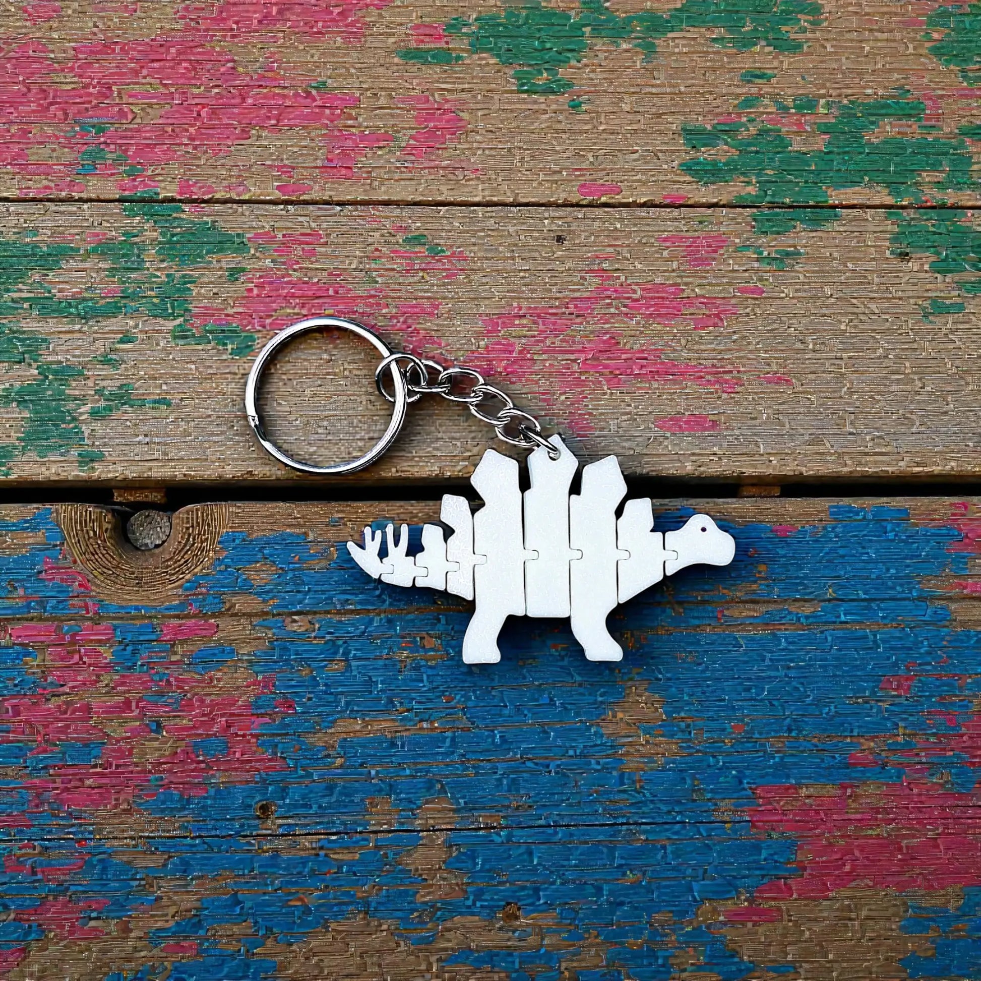 Handmade and customizable dinosaur fidget keychain, featuring colorful articulated designs, perfect for kids birthday parties, classroom prizes, sensory play, and party favor dino gifts.
