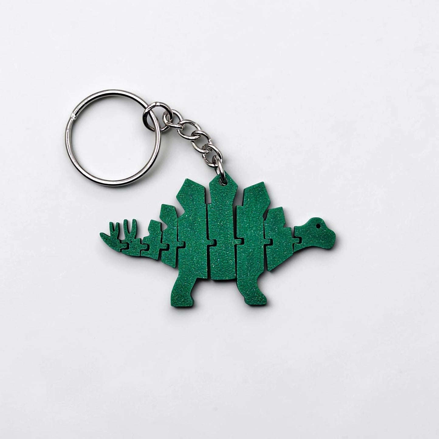 Handmade and customizable dinosaur fidget keychain, featuring colorful articulated designs, perfect for kids birthday parties, classroom prizes, sensory play, and party favor dino gifts.