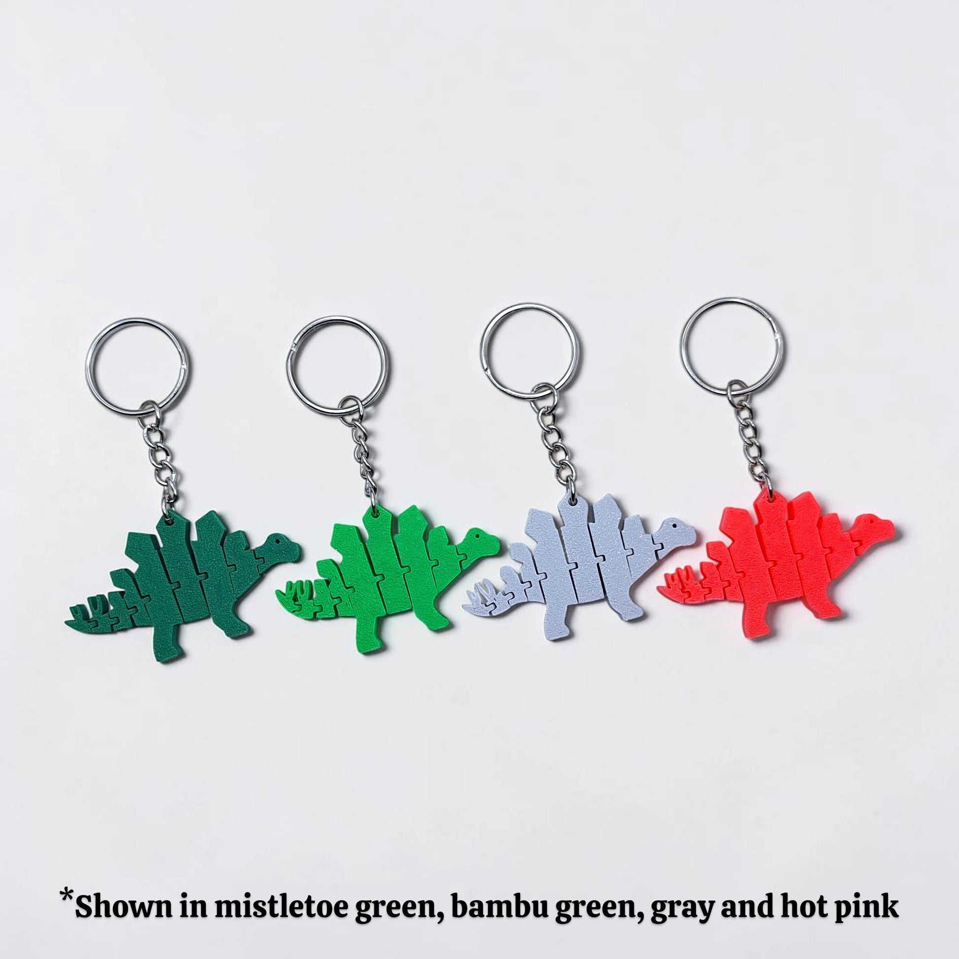 Handmade and customizable dinosaur fidget keychains in assorted colors, featuring colorful articulated designs, perfect for kids birthday parties, classroom prizes, sensory play, and party favor dino gifts.