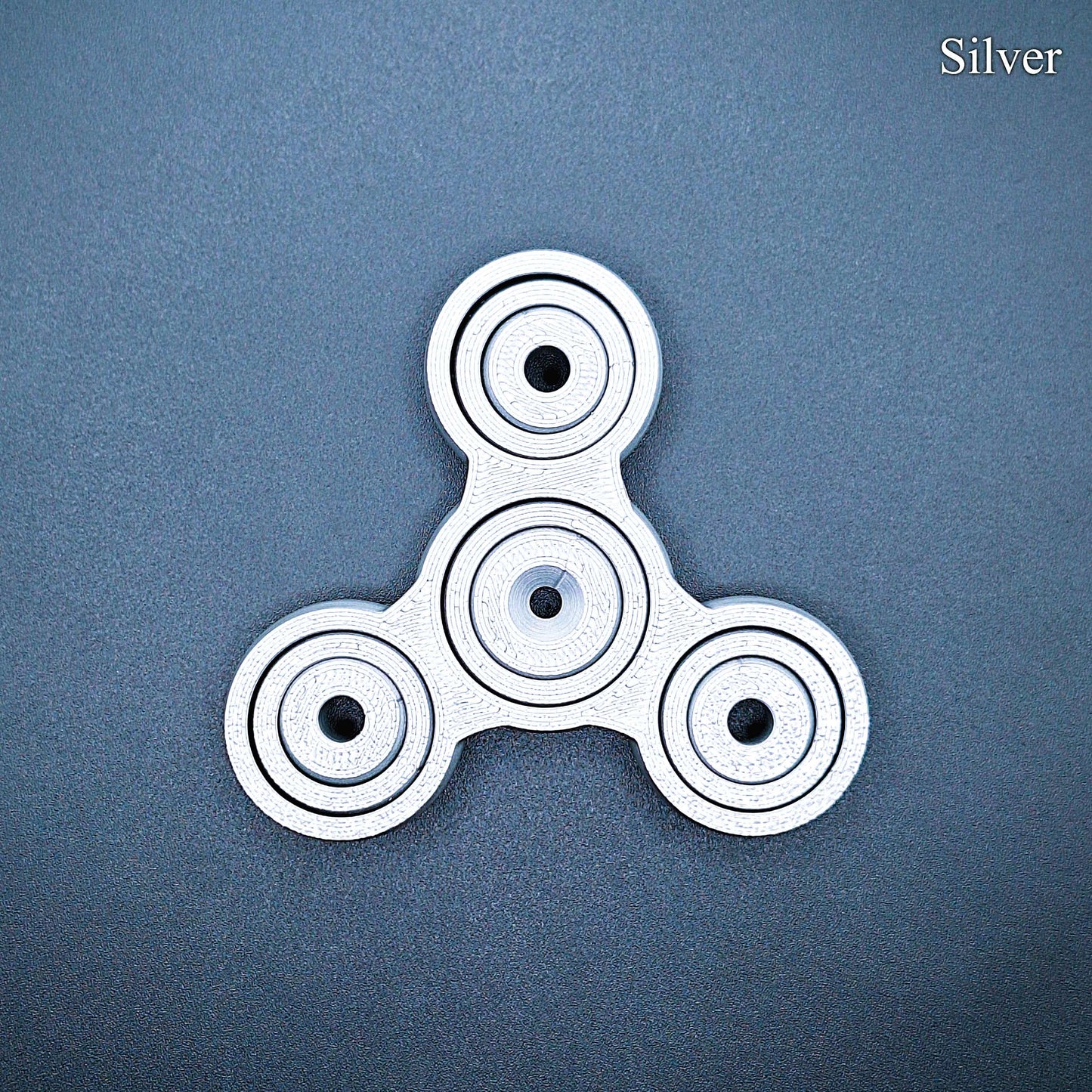Silver 3" fidget gyro spinner with pronged design—great for anxiety, ADHD focus, and quiet sensory play. Handmade from PLA plastic.