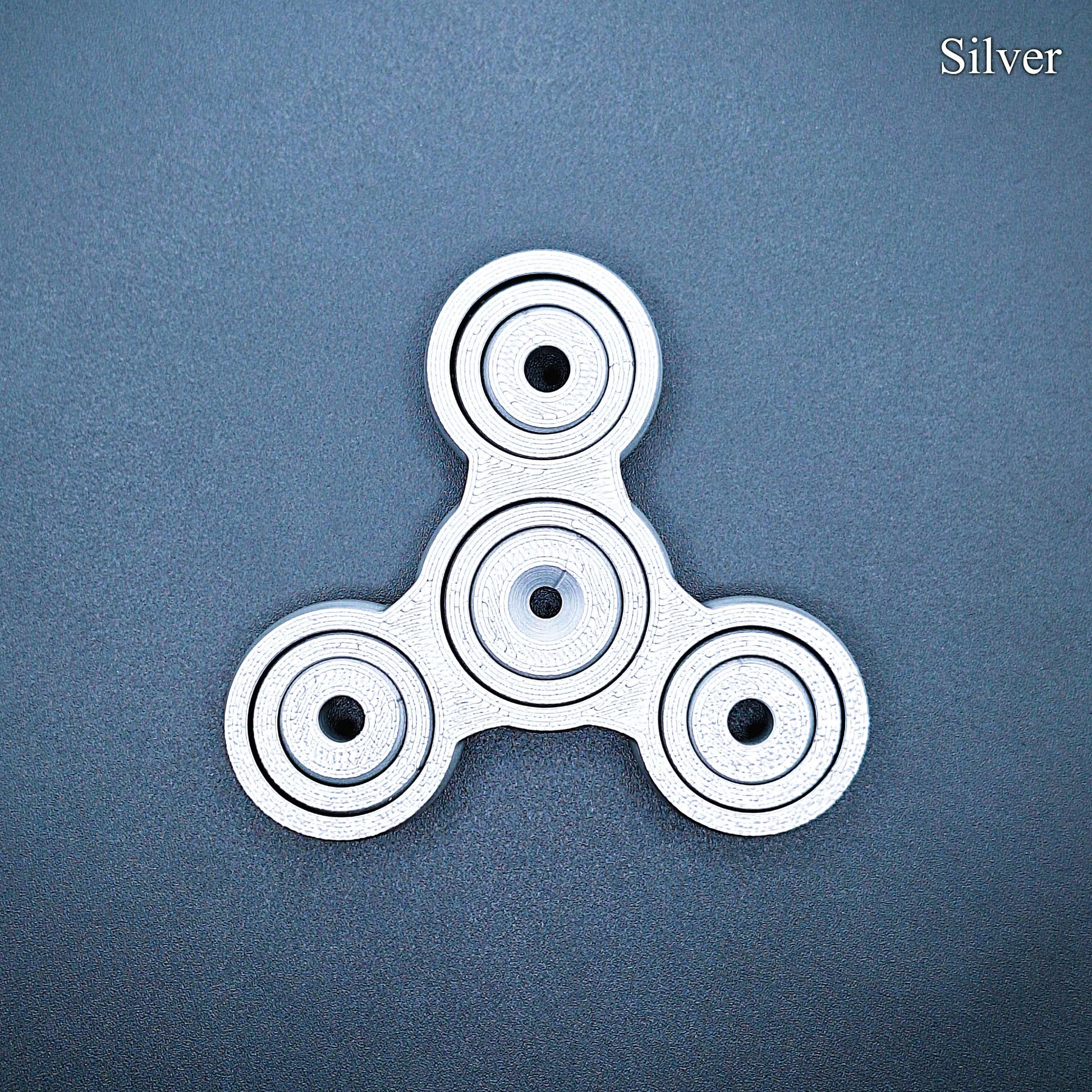 Silver 3" fidget gyro spinner with pronged design—great for anxiety, ADHD focus, and quiet sensory play. Handmade from PLA plastic.