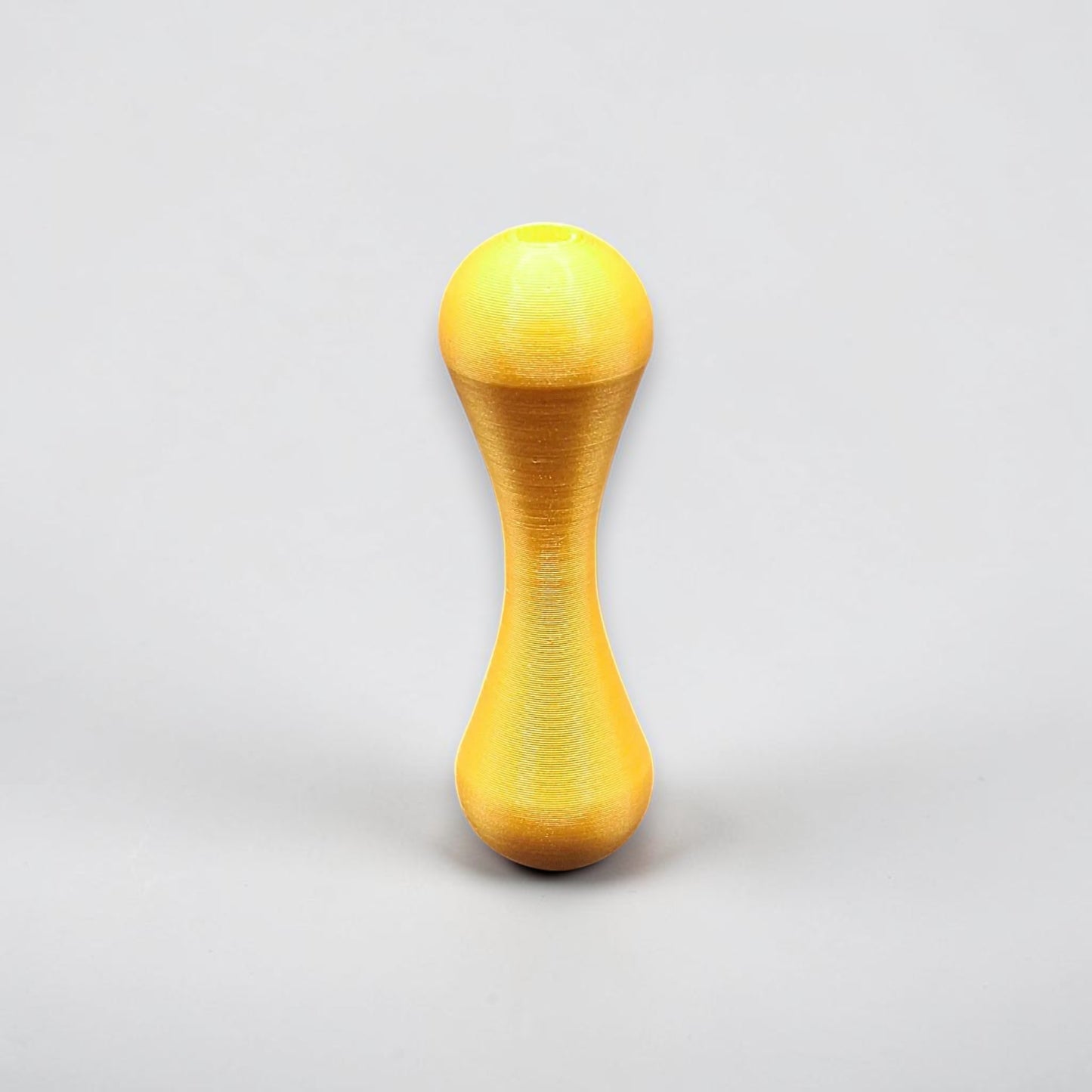 Gold knucklebone fidget toy with sleek finish, handmade from biodegradable PLA plastic for smooth flips, rolls, and sensory focus.