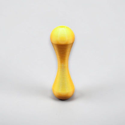Gold knucklebone fidget toy with sleek finish, handmade from biodegradable PLA plastic for smooth flips, rolls, and sensory focus.