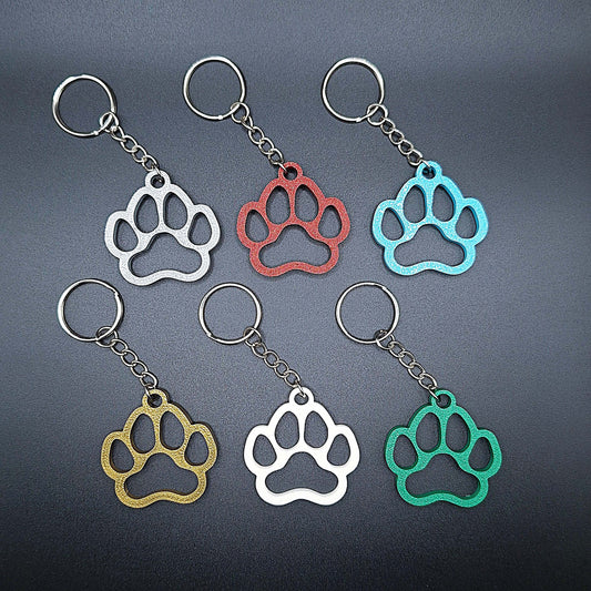 Six paw print keychains in assorted colors, made from biodegradable PLA plastic, perfect for dog moms, cat lovers, or rescue volunteers.