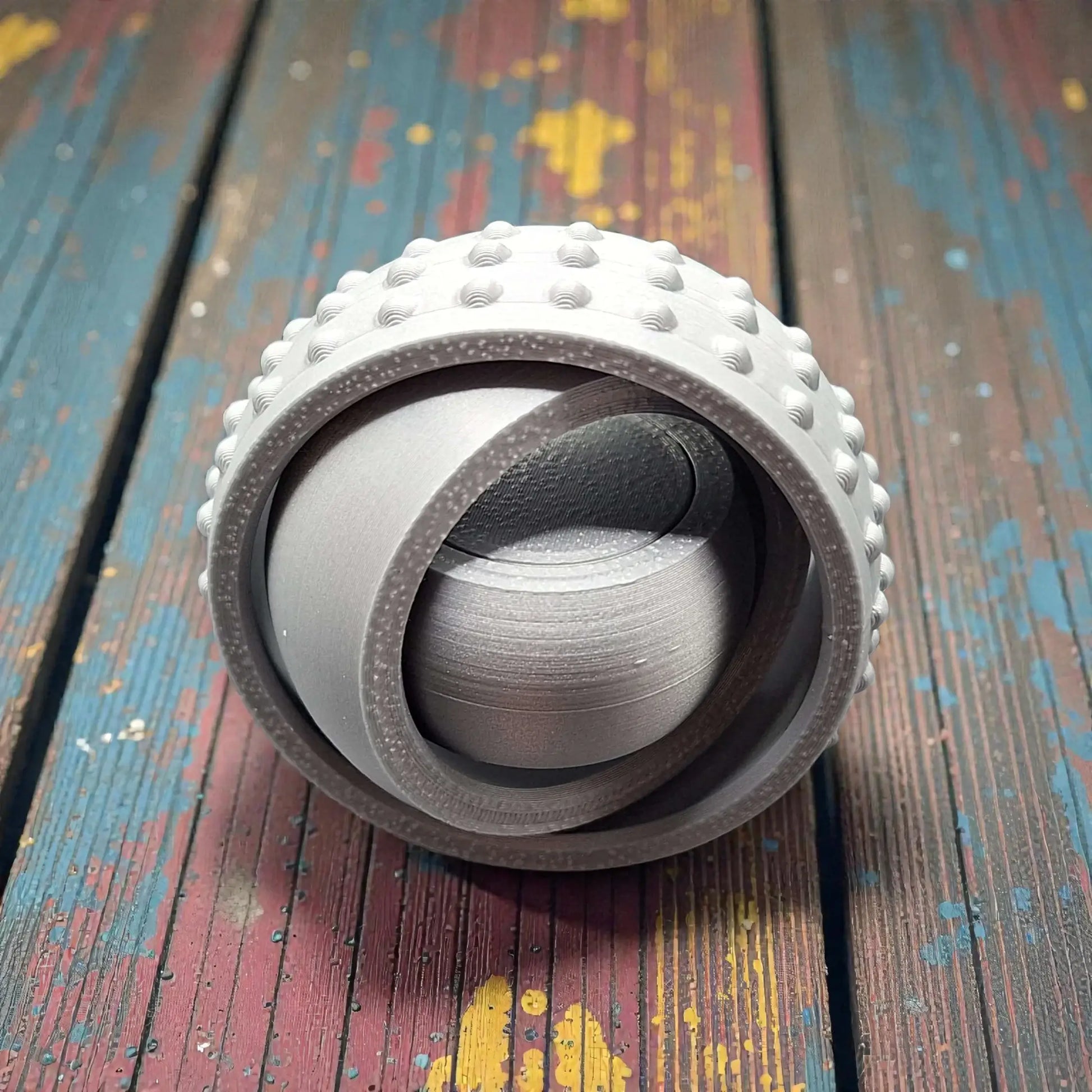 Front view of silver pocket-sized fidget spinner, minimal and modern design made from plant-based plastic for portable stress relief.