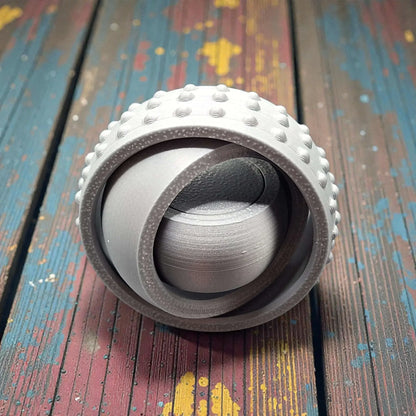 Front view of silver pocket-sized fidget spinner, minimal and modern design made from plant-based plastic for portable stress relief.