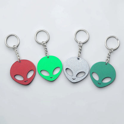 Alien head keychains in four different colors displayed side by side, perfect for sci-fi fans, party favors, or fun personalized gifts.