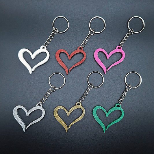 Close-up of six sleek heart keychains in assorted shades, modern and minimalist in style, crafted from sustainable PLA for gift or daily use.