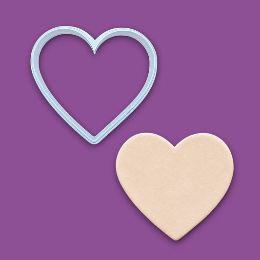 Heart cookie cutter alongside a dough cutout. Perfect for layered cookies, fondant, crafts, weddings, and Valentine’s Day baking fun.