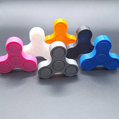 Six mini fidget spinners shown against a black background, handmade in vibrant colors and ideal for quiet, stress-relieving play and focus.
