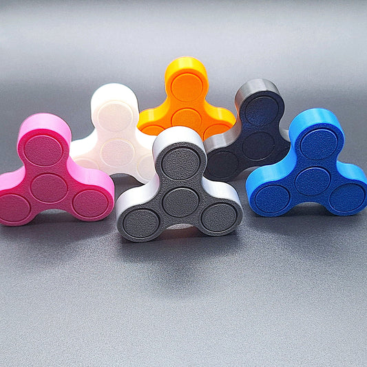 Six mini fidget spinners shown against a black background, handmade in vibrant colors and ideal for quiet, stress-relieving play and focus.