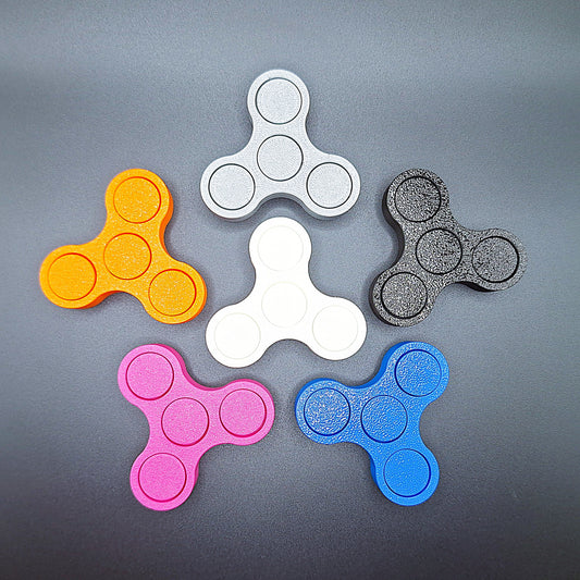 Top-down view of six mini fidget spinners in various colors, perfect for spinning, fidgeting, and boosting concentration anywhere.