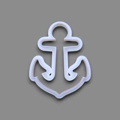 A white plastic anchor-shaped cookie cutter, shown from a top-down view on a solid gray background.