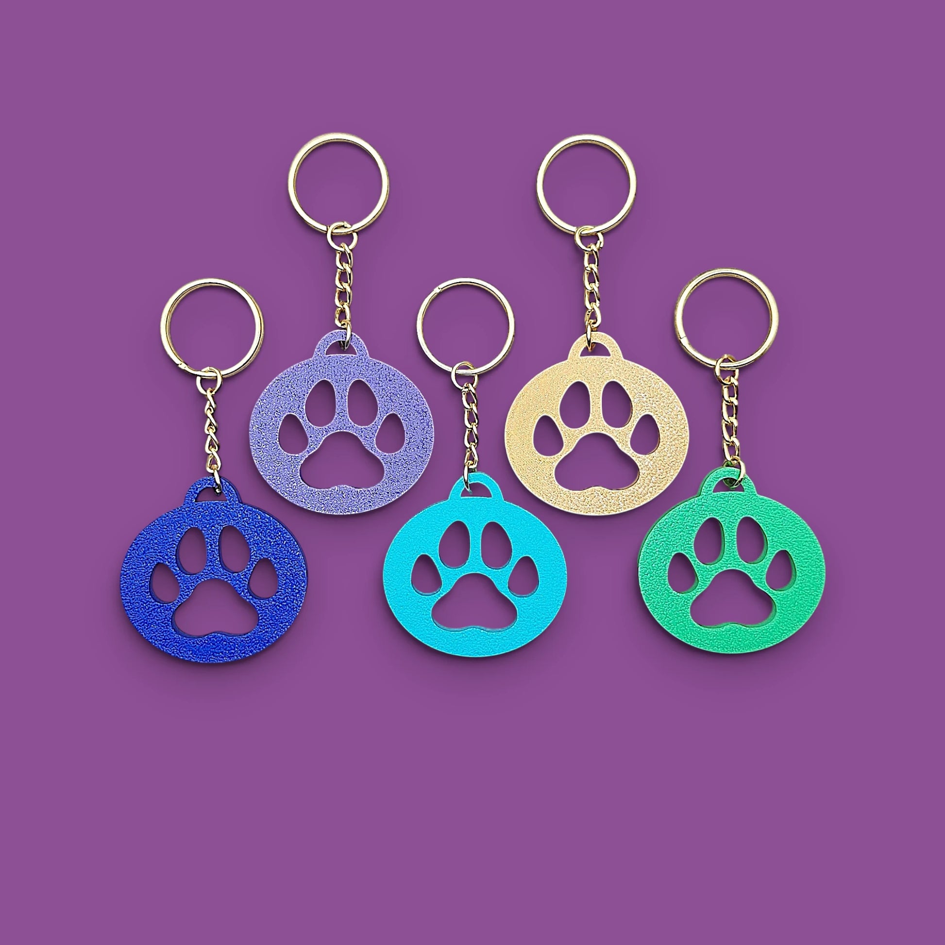 Paw print keychains, perfect for dog moms, cat lovers, rescue volunteers, shelter giveaways, and vet clinics. Handmade and customizable in 30 unique colors.