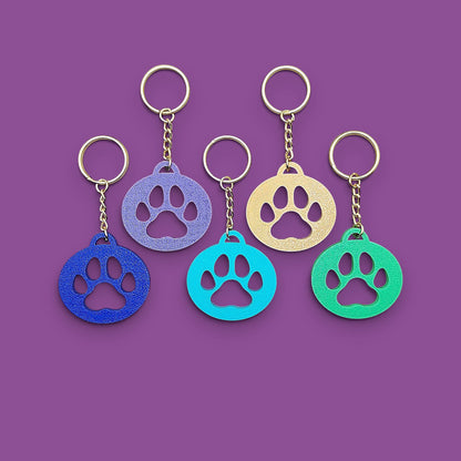 Paw print keychains, perfect for dog moms, cat lovers, rescue volunteers, shelter giveaways, and vet clinics. Handmade and customizable in 30 unique colors.