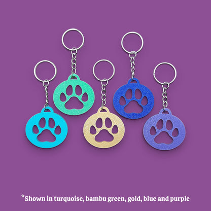 Paw print keychains in various colors, perfect for dog moms, cat lovers, rescue volunteers, shelter giveaways, and vet clinics. Handmade and customizable in 30 unique colors.