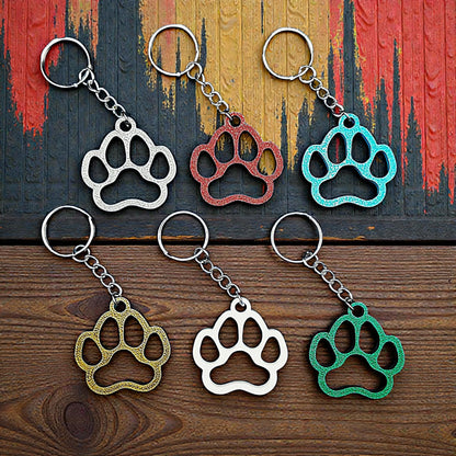 Six paw print keychains in assorted colors, made from biodegradable PLA plastic, perfect for dog moms, cat lovers, or rescue volunteers.