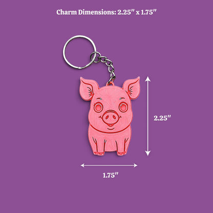 A pink pig-shaped keychain charm with a silver keyring, shown on a light gray background with dimension labels reading "2.25 x 1.75"
