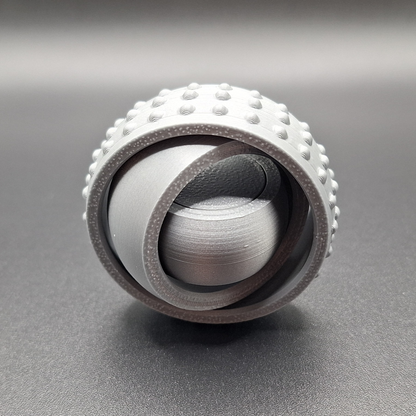 Front view of silver pocket-sized fidget spinner, minimal and modern design made from plant-based plastic for portable stress relief.