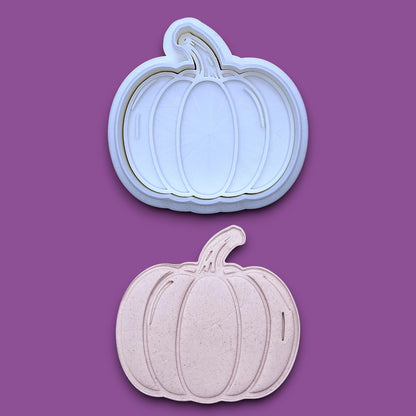 Pumpkin cookie cutter and stamp along with a pumpkin dough cutout, perfect for fall, Halloween, and Thanksgiving-themed baking or crafts.