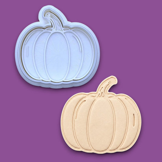 Pumpkin cookie cutter and stamp along with a pumpkin dough cutout, perfect for fall, Halloween, and Thanksgiving-themed baking or crafts.