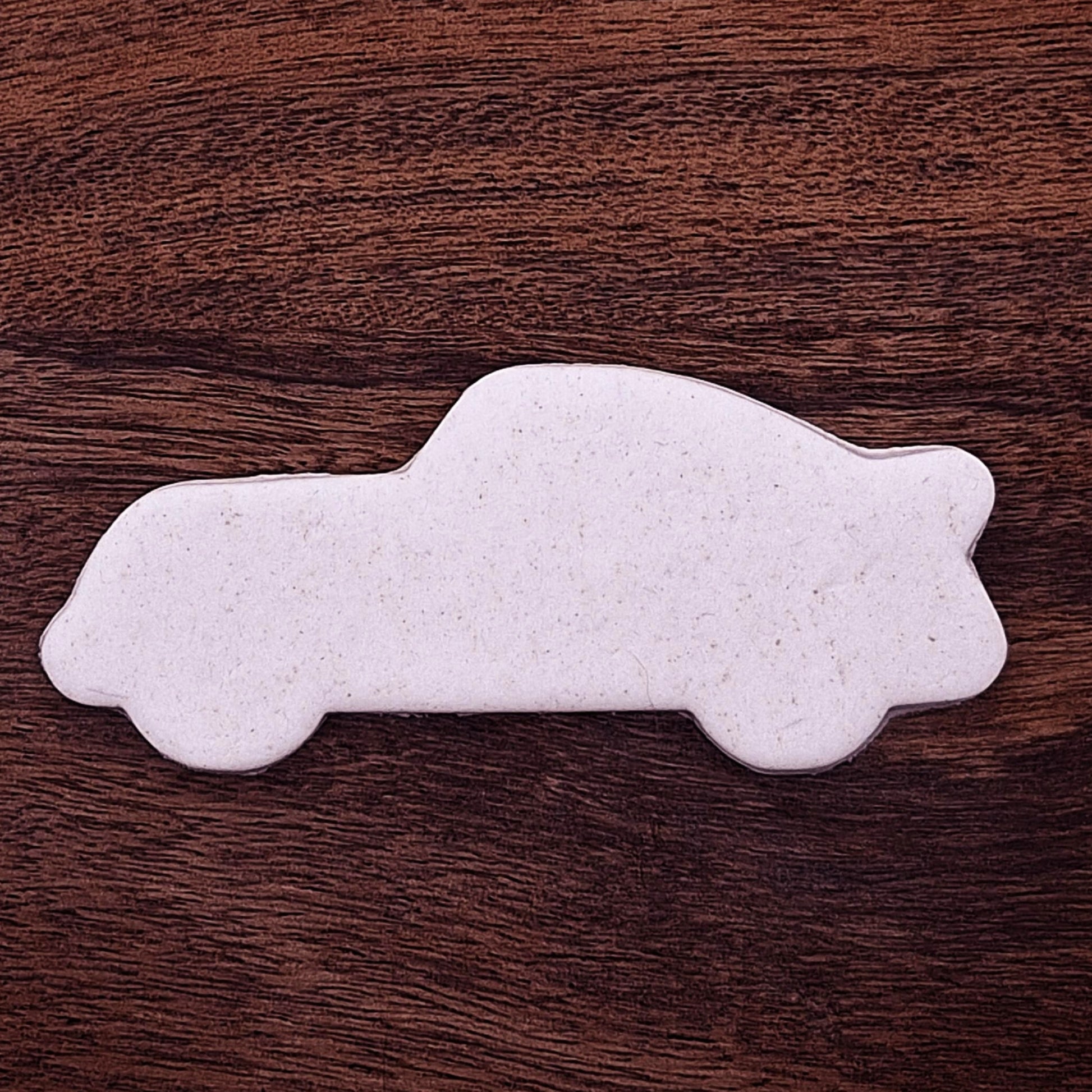 Racecar cookie dough cutout with detailed stamped design. Perfect for racing-themed birthday treats, car cookies, or fun fondant decorations.