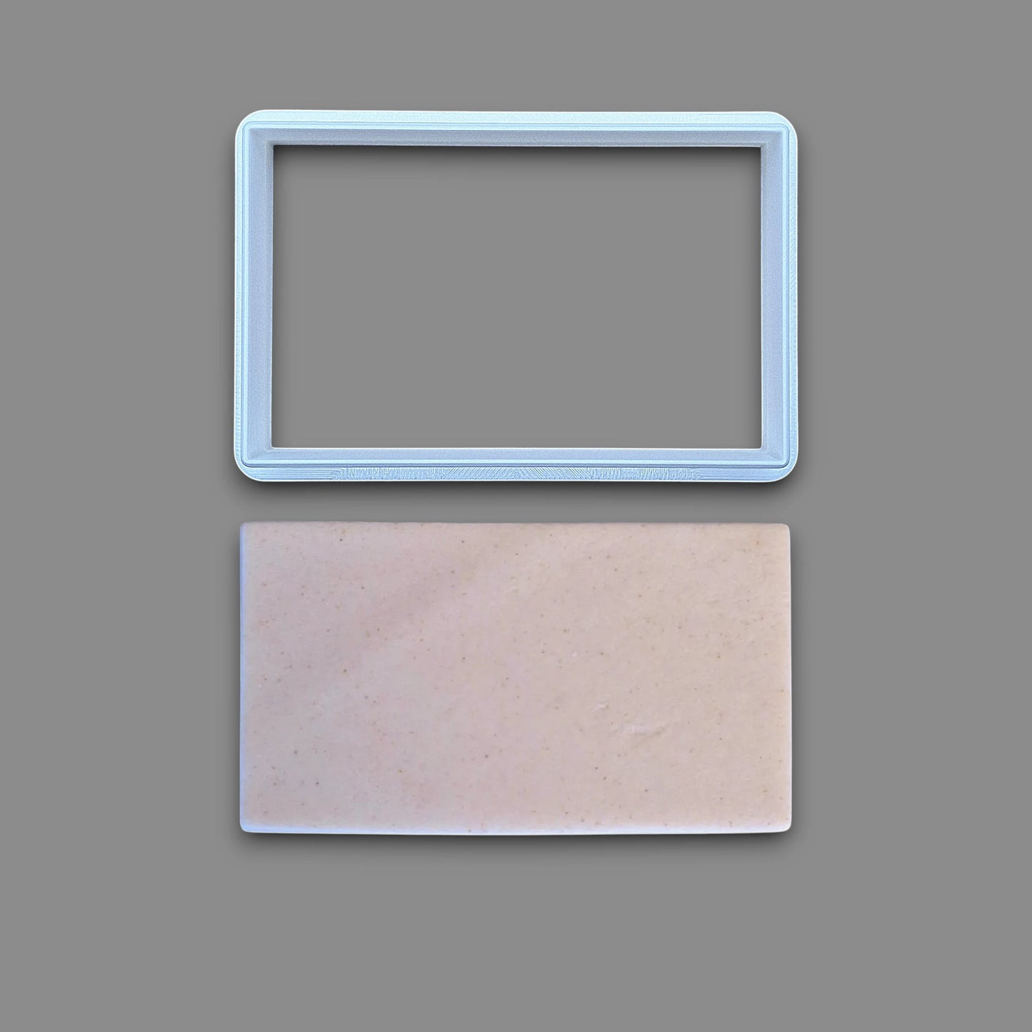 Rectangle cookie cutter alongside a dough cutout, perfect for baking classic shapes, fondant, parties, clay and crafts.