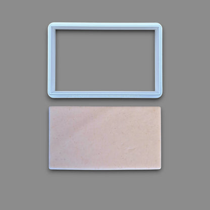 Rectangle cookie cutter alongside a dough cutout, perfect for baking classic shapes, fondant, parties, clay and crafts.