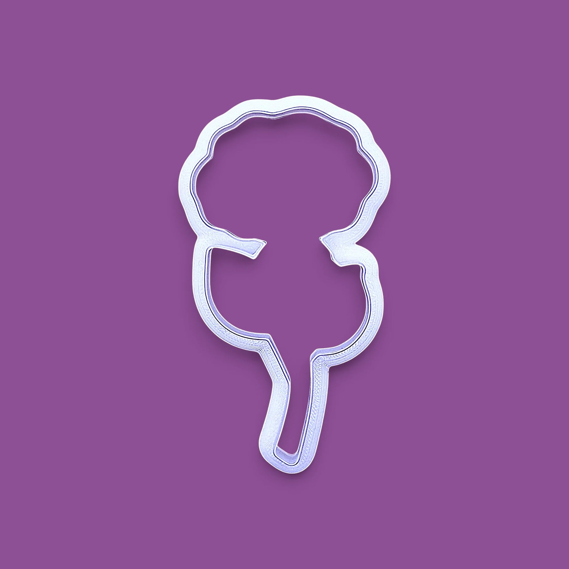 A white cookie cutter in the shape of a rose, shown on a solid purple background.