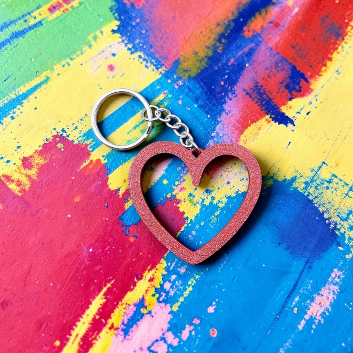 Heart keychain shown in maroon red on colorful background, perfect for Valentine's Day gifts, wedding party favors, stocking stuffers and class prizes.