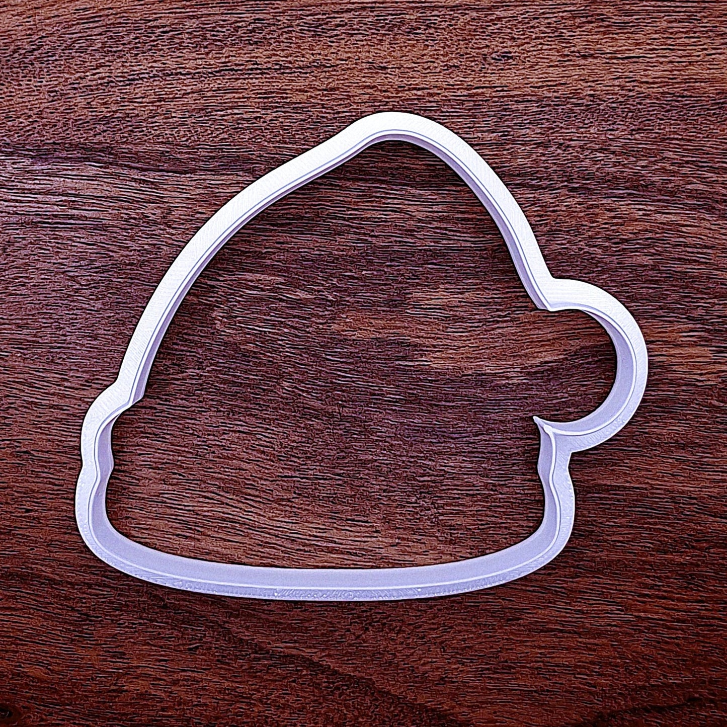 Cookie cutter shaped like a Santa hat. Clean edge design for fun holiday cookie baking or crafting.