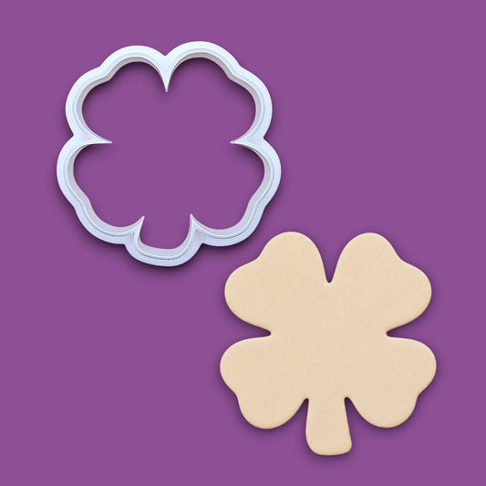 A four-leaf clover cookie cutter shown above its matching cutout.