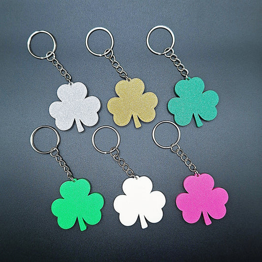 Six shamrock keychains in a variety of colors including green, bronze, and magenta, showing a classic 3-leaf clover shape perfect for Irish gifts.