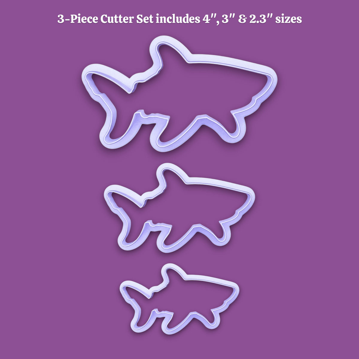 Three shark-shaped cookie cutters in different sizes displayed on a solid purple background, with white text at the top reading '3-Piece Cutter Set includes 4", 3", & 2.3" sizes'.