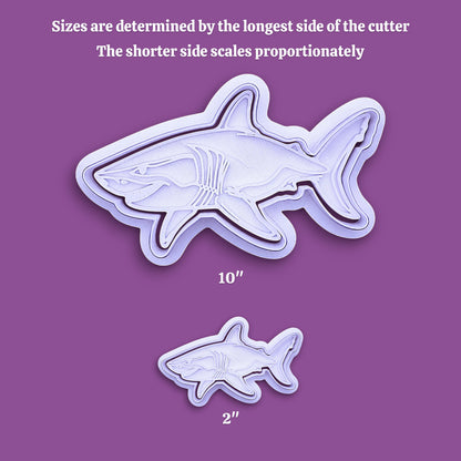 Two shark-shaped cookie cutters shown on a purple background, with text explaining that sizes are determined by the longest side of the cutter and that the shorter side scales proportionately. The larger cutter is labeled 10 inches and the smaller one 2 inches.
