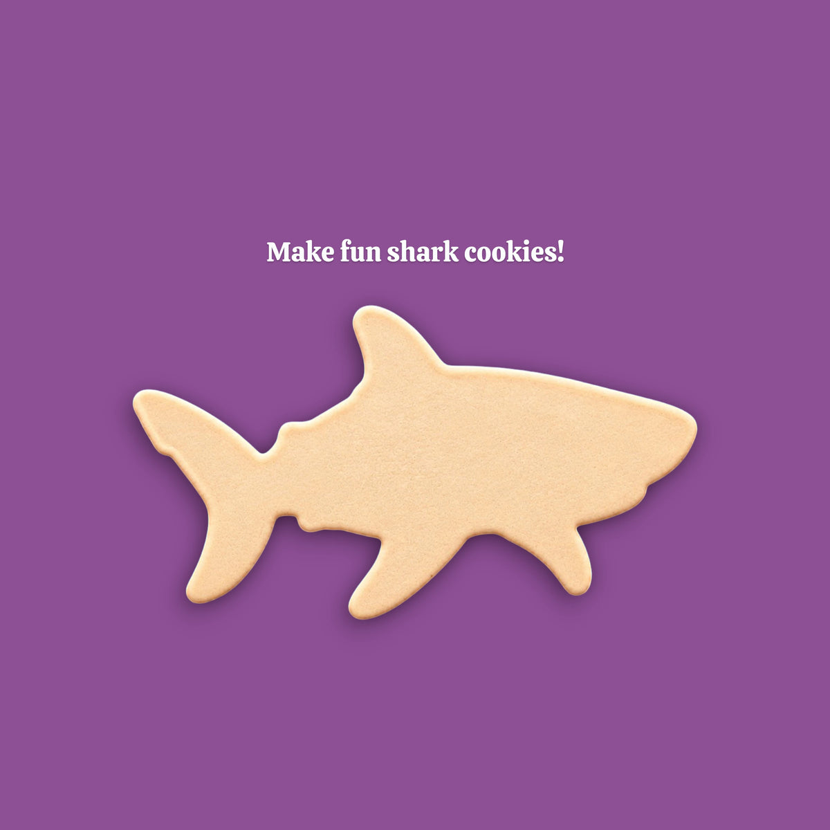 A shark-shaped cookie centered on a solid purple background, with the white text 'Make fun shark cookies!' above it.