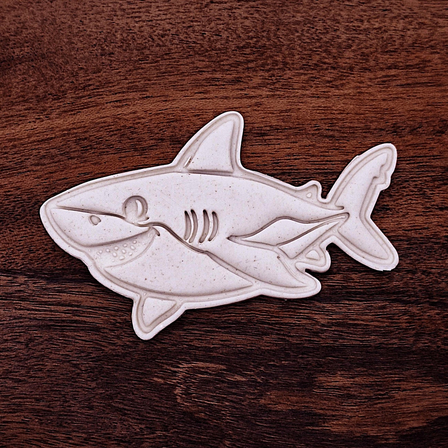 Smiling shark cookie dough cutouts with stamped fin and face detail. Perfect for beach parties, ocean birthdays, and kid-friendly shark bakes.