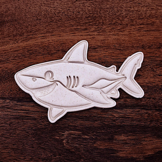 Smiling shark cookie dough cutouts with stamped fin and face detail. Perfect for beach parties, ocean birthdays, and kid-friendly shark bakes.