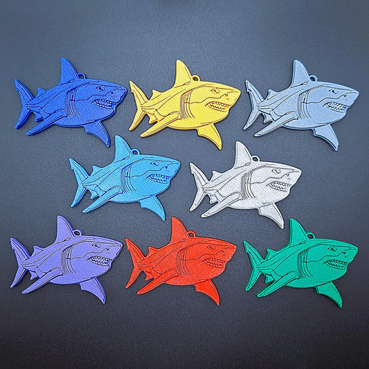 Front view of 8 shark keychains in assorted colors. Marine life key ring set, handmade in the USA with compostable PLA for sea lovers and gift bags.