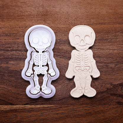 Skeleton cookie cutter stamp beside a dough imprint, perfect for outline cookies, fondant toppers, or Halloween crafts.
