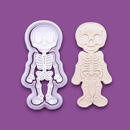 Skeleton cookie cutter stamp beside a dough imprint, perfect for outline cookies, fondant toppers, or Halloween crafts.