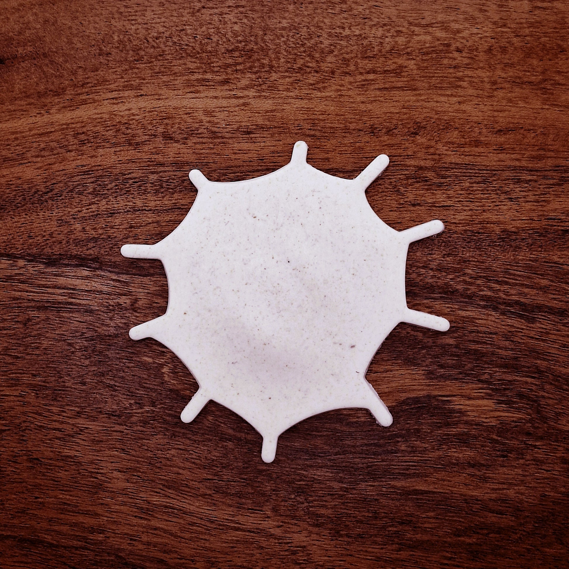 Cookie dough cutout of spiderweb made using the cutter. Ideal for spooky snacks and Halloween party trays.