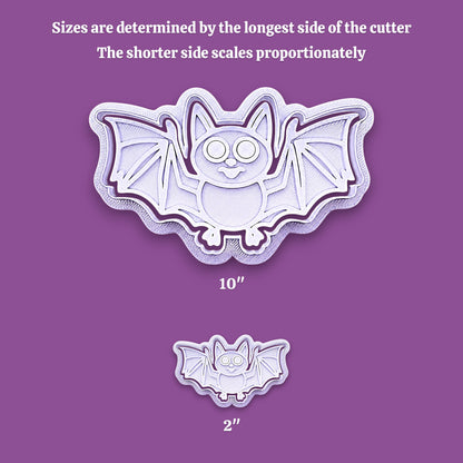 Bat-shaped cookie cutter shown in two sizes on a purple background, with text explaining that sizes are determined by the longest side of the cutter and that the shorter side scales proportionately. The larger cutter is labeled 10 inches and the smaller one 2 inches.